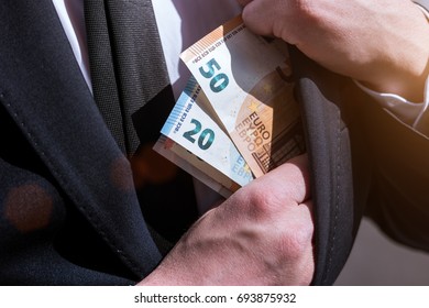money in the pocket of a business man suit - Shutterstock ID 693875932