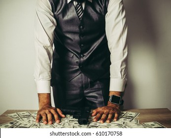 Money and power, Senior gangster with gun, in suit at the table. - Shutterstock ID 610170758