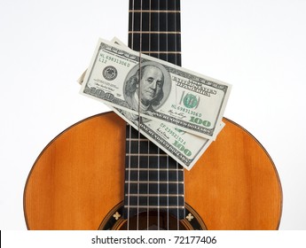 Money put between the chords of a classical guitar.
