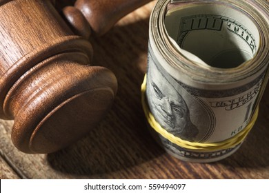 Money Roll And Judges Hammer On Wooden Table, Top View