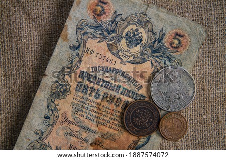 Money of the Russian Empire at the beginning of the 20th century. The picture shows 5 rubles, coins 1 ruble, 3 kopecks and one kopeck.