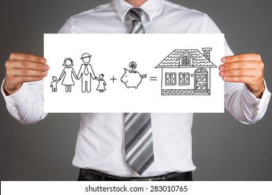 Money Saving Concept.Business Man Holding A Drawing Of A Family,saving Money To Buy A House.