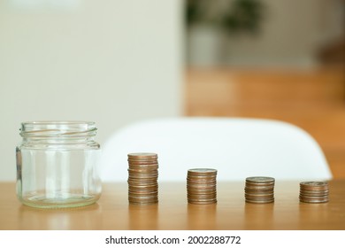 Money Saving And Finance Concept. Empty Jar And Money On A Wooden Table. She Saving The Money For The Future, Education, Investment And Retirement.