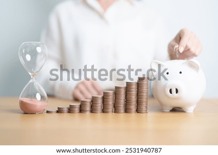 Money Saving for Future Plan, Retirement fund, Pension, Investment, Wealth Business and Financial concepts. coins stack, piggy bank with sandglass on table