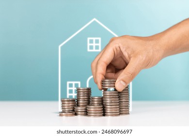 Money saving, real estate investment, investing for home lone and property profit. Hand putting money coin stack with home symbol - Powered by Shutterstock