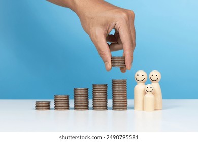 Money saving, real estate investment, family, Invest, profit and finance. A man hold coin and coins stack and wooden figurines family happy and increasing piles of coins - Powered by Shutterstock