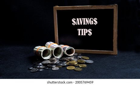 Money Saving Tips Concept. Selective Focus On The Green Board  With A Text Saving Tips. How To Save Money Fro Holiday, Paying Loan Or Investment Concept