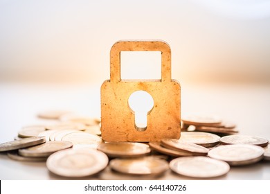 Money And Security Concept. Wooden Master Key Lock Icon On Pile Of Coins.