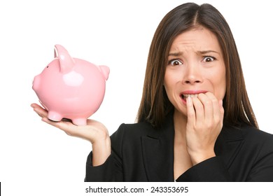 Money stress - business woman holding piggy bank. Debt, bankruptcy and savings concepts with stressed female businesswoman biting nails nervous isolated