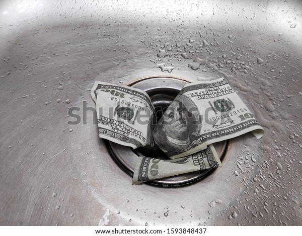 Money\
is thrown away in the sink. This photo concept illustrates the\
financial condition of a business that is failing or going bankrupt\
so that it only wastes money without\
results.\
\
