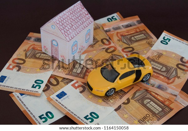 money toy car and house, top and side view on\
dark background