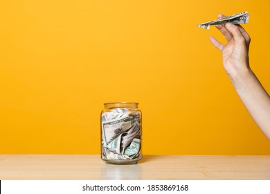 Money Transfers, Deposits To A Foreign Currency Account. Hand With An Airplane From A Banknote Near A Bank With Money, Yellow Background