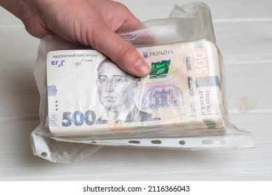 Money Of Ukraine. Stack Of Ukrainian Hryvnia Banknotes In Plastic Transparent Bag In Hands As Bribe Concept 500 Uah