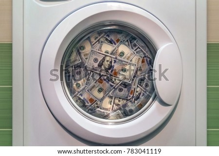 money in washing machine close up. concept of laundering illegal money. washing dirty American banknotes nominal value one hundred dollars