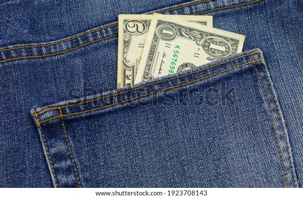 Money in your pocket. Dollar\
bills in the back pocket of jeans. The concept of pocket\
money.