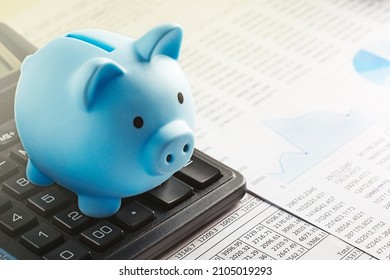 Moneybox for money on the background of documents and financial charts. Investment and capital accumulation concept. - Shutterstock ID 2105019293