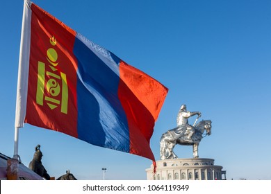 Mongolia Flag With Soft Blur Chinggis Khan Statue In Background