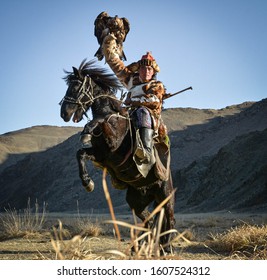 Mongolian Eagle Hunters In Traditionally Wearing Typical Mongolian Fox Dress Culture Of Mongolia On Altai Mountains