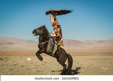 Mongolian Eagle Hunters In Traditionally Wearing Typical Mongolian Fox Dress Culture Of Mongolia On Altai Mountains