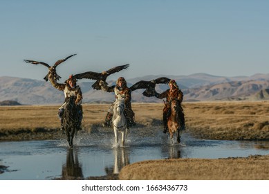 Mongolian Eagle Hunters In Traditionally Wearing Typical Mongolian Fox Dress Culture Of Mongolia On Altai Mountain Background At Ba-yan UiGII, MONGOLIA