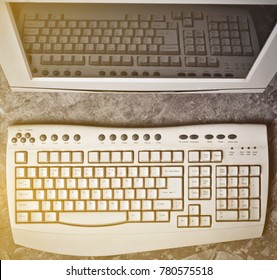 A monitor and keyboard retro stationary personal computer on a concrete table. Top view. - Shutterstock ID 780575518