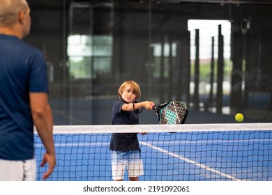 Monitor teaching padel class to child, his student - Trainer teaches little boy how to play padel on indoor tennis court - Shutterstock ID 2191092061