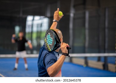 Monitor teaching padel class to man, his student - Trainer teaches boy how to play padel on indoor tennis court - Shutterstock ID 2012645378