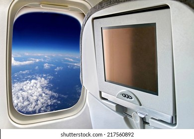 Monitor and a window on the plane. Space trip with the spacecraft. View of the planet earth from an airplane window.