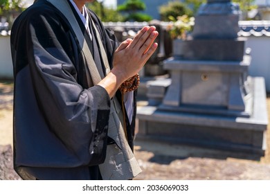 A Monk Praying In Front Of The Tomb