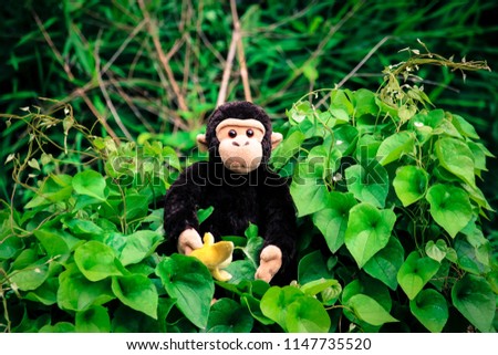 The monkey doll is happy sitting on a tree bush.