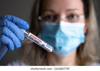 Monkey pox PCR test tube in doctors hand, medical worker in face mask shows swab collection kit for smallpox virus diagnosis and monkeypox research. Concept of monkey pox testing, care and health.