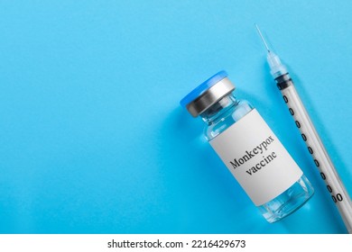 Monkeypox Vaccine In Glass Vial And Syringe On Light Blue Background, Flat Lay. Space For Text