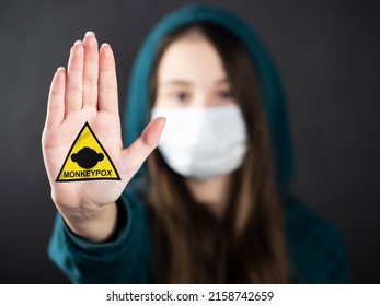 MONKEYPOX.Teenage girl wearing a mask to protect against diseases shows a hand gesture to stop the outbreak of the MONKEYPOX virus. Virus, epidemic, disease.