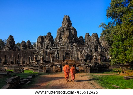 The monks in the ancient stone faces of Bayon temple, Angkor, Cambodia