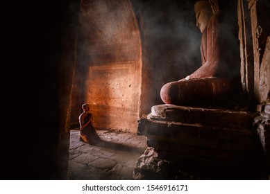 A Monks of Buddhism come make meditation and respect Ancient buddha statue at Dhammayangyi Temple a Buddhist temple located in Bagan, Myanmar,with sunlight ray background