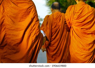 monks dressing orange robe during reception of alms, around buddhist temple - Powered by Shutterstock