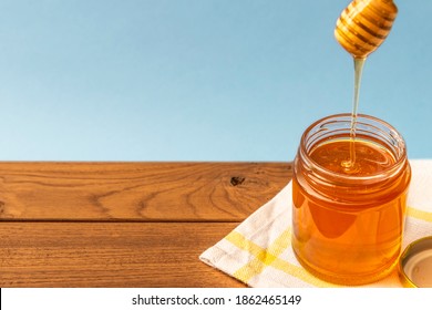 Mono floral natural Honey with a bottle pouring tabletop composition honeycomb with a honey spoon, honey dripper multi background, wood background, white background with a bowl, natural sweetener