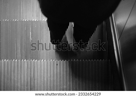 monochome The man walking on Escalator in metro. Moving down staircase.