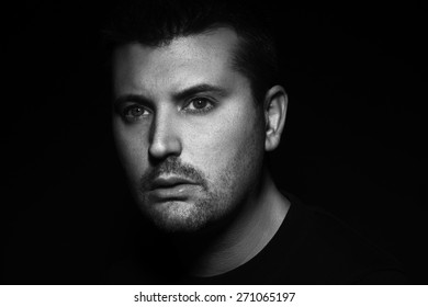 Monochromatic Portrait Of Handsome Young Man Against Dark Background