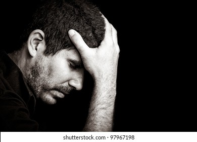 Monochromatic Portrait Of A Worried Or Depressed Young Hispanic Man Isolated On Black