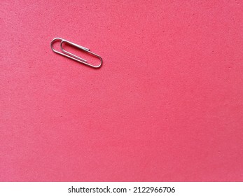 Monochromatic Red Background With Small Deep Pores With A Gray Paperclip