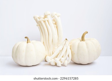 Monochromatic still life of vegetables. Little pumpkin and beech mushrooms on white. - Powered by Shutterstock