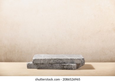 Monochrome beige template for mockup, banner. Flat granite pedestal on beige background. Stone stand for natural design concept. Horizontal image, center composition, hard light, front view