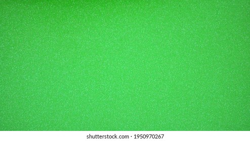 Monochrome bright green surface with a scattering of small silvery shiny blotches. Background, pattern, texture.