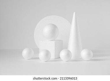 Monochrome composition of various 3d geometric shapes. White balls of different sizes, cube, cone, on an isolated background. Concept of visual aid.