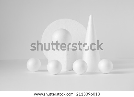 Monochrome composition of various 3d geometric shapes. White balls of different sizes, cube, cone, on an isolated background. Concept of visual aid.