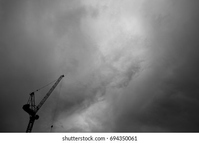 Monochrome: Construction crane with blank expression on cloudy sky