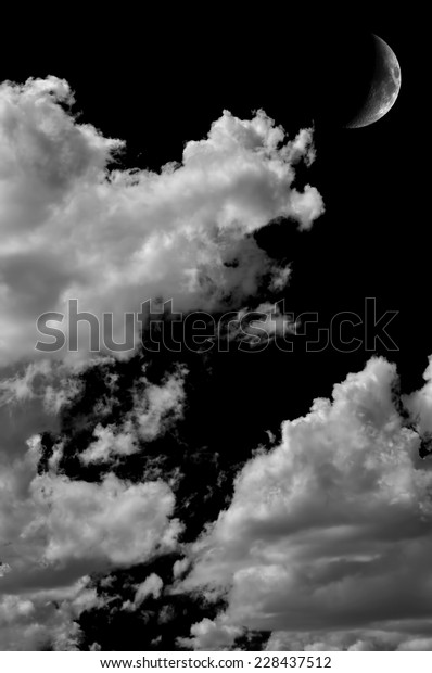 Monochrome image of moon\
and clouds at nigh