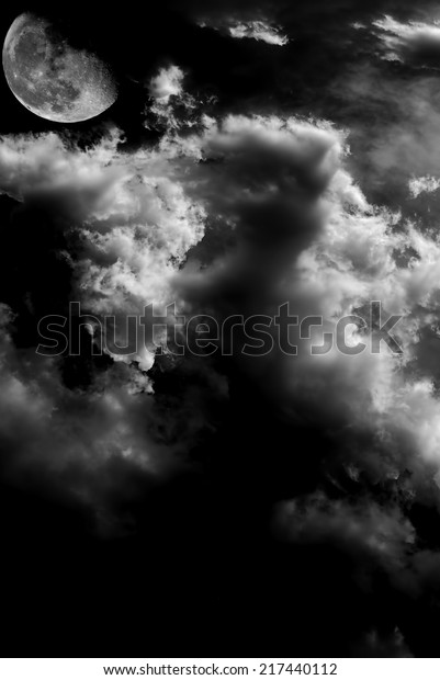Monochrome image of\
moon and clouds at\
night