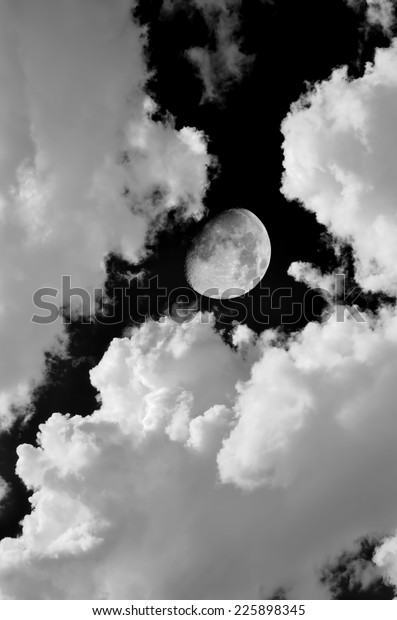 Monochrome image of\
moon and clouds at\
night